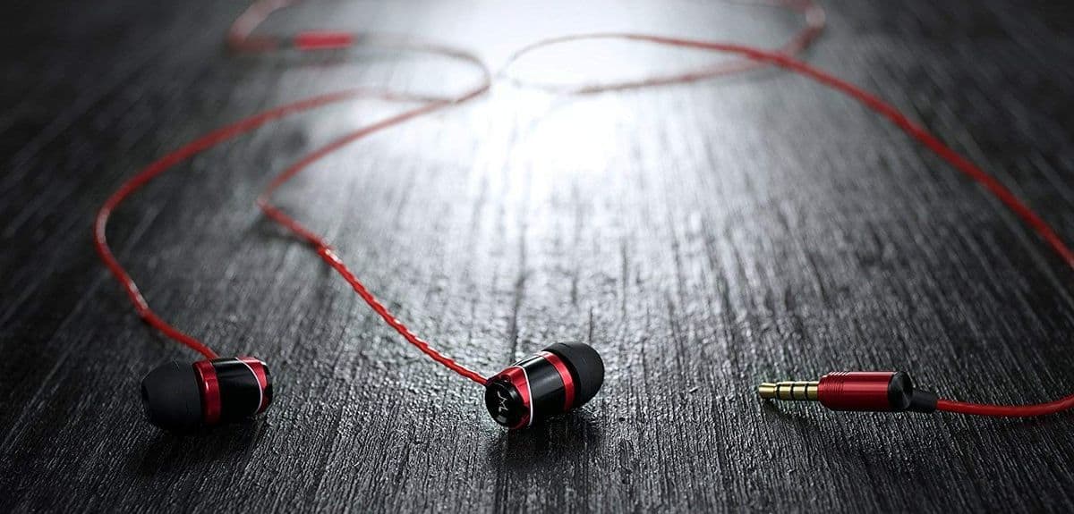 Soundmagic E10 In-Ear-Kopfhörer – Ohrhörer ausgebreitet auf dunkler Oberfläche